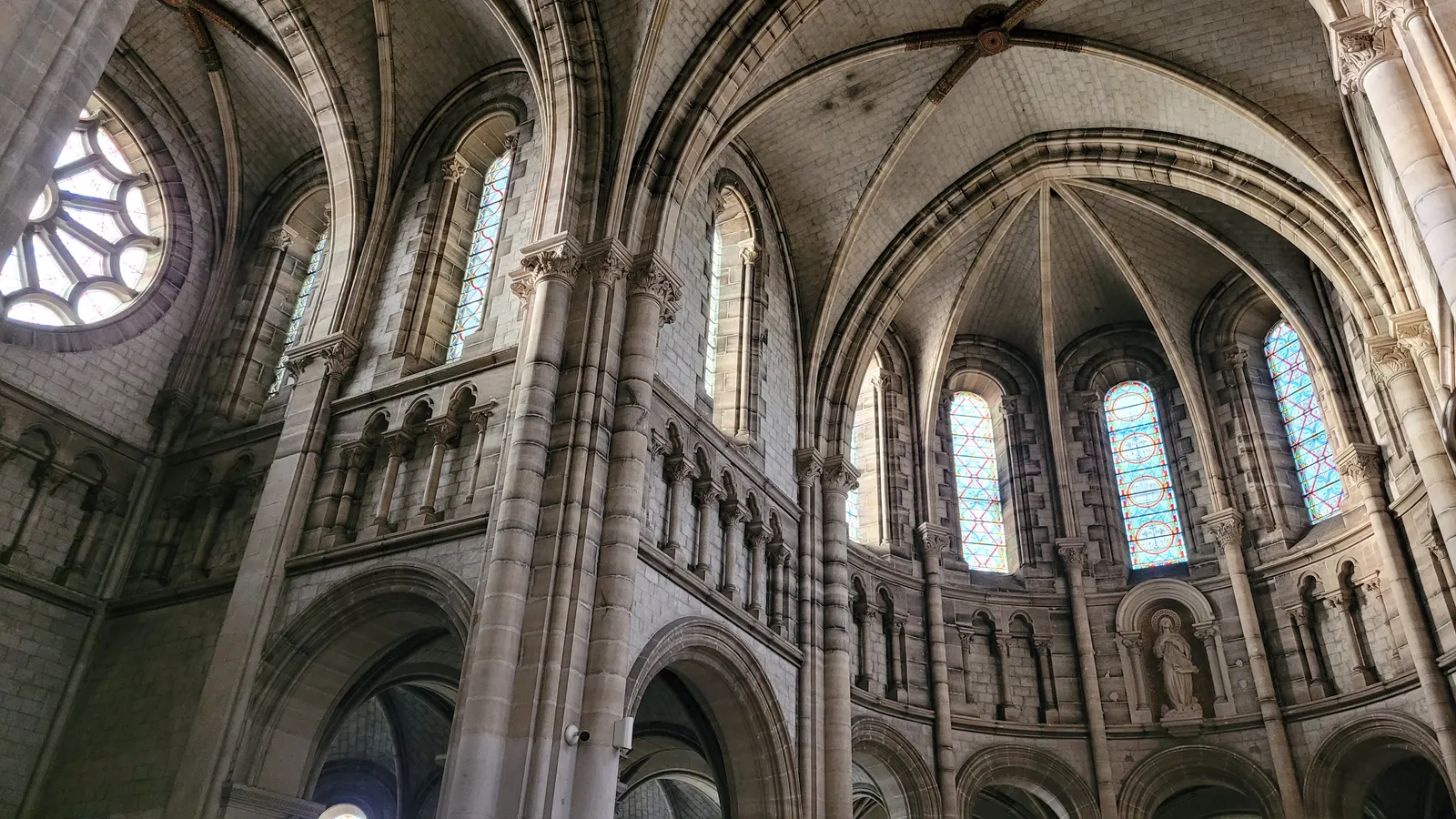 Les voûtes, les arcades et les vitraux de l’église abbatiale, vus depuis la nef