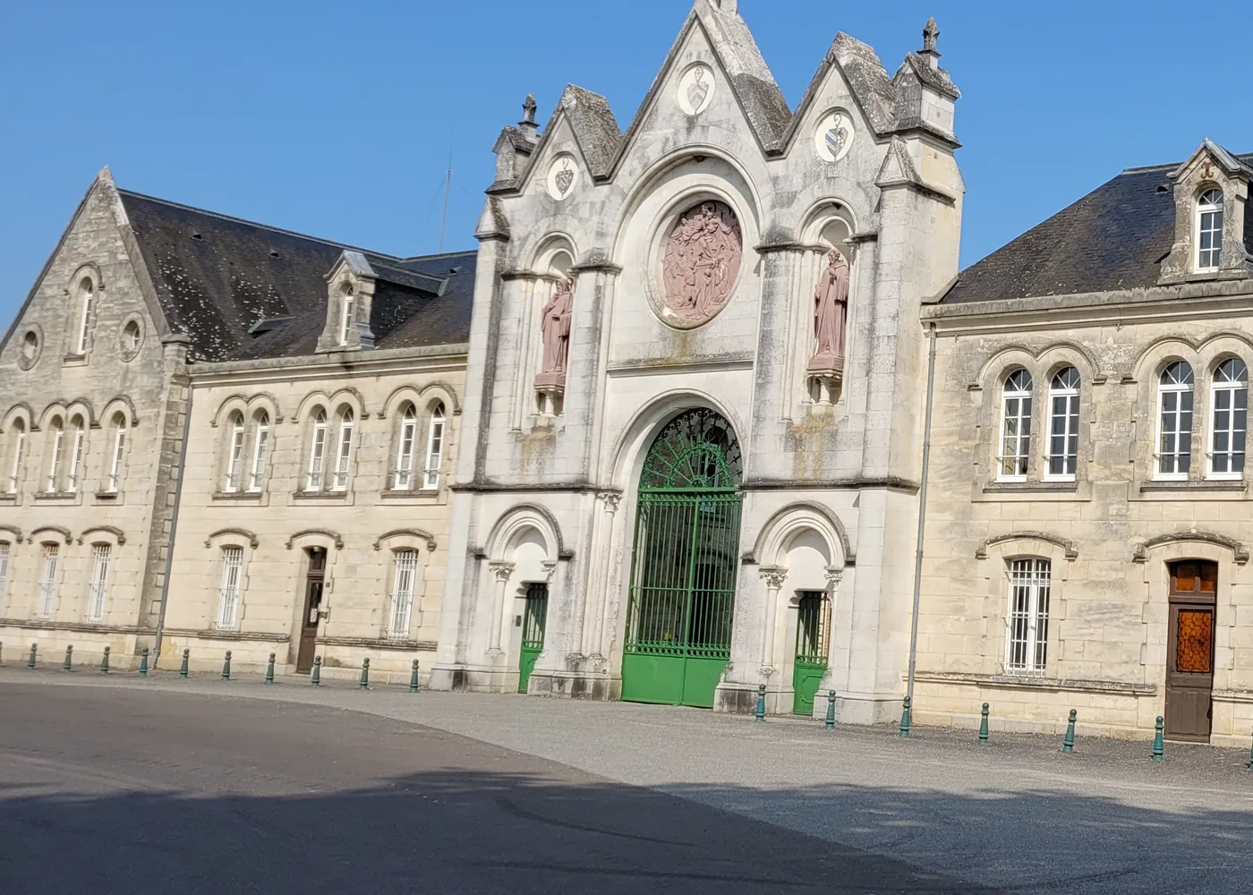 Le portail d’entrée de l’abbaye, sa rosace et sa grille verte